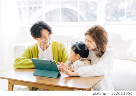 リビングでタブレットを見る家族 102611950