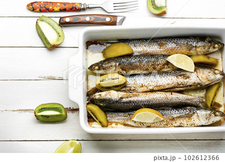 Baked whole fish with kiwi and lime. 102612366