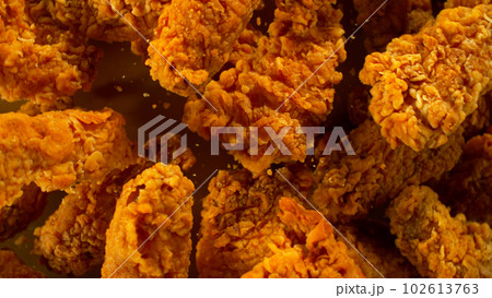 Freeze Motion Shot of Flying Fresh Fried Chicken Wings or Strips, Close-up Freeze Motion Shot of Flying Fresh Fried Chicken Wings or Strips, Close-up 102613763