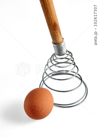 Beige chicken egg and spiral whisk. Ingredients for cooking isolated on white background Beige chicken egg and spiral whisk. Ingredients for cooking isolated on white background 102617307