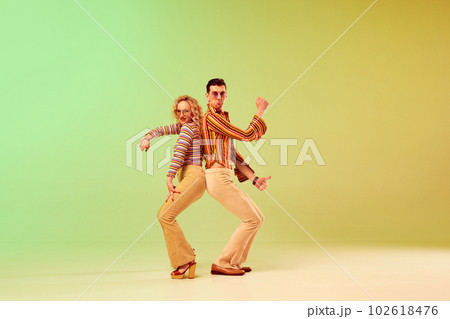 Choreography. Two talented people, autistic man and woman in vintage clothes dancing against gradient green yellow background 102618476