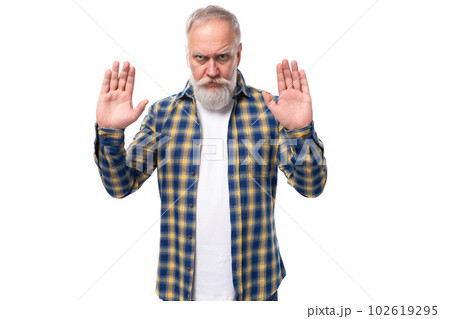 mature gray-haired man with a beard in a shirt shrugs his shoulders on a white background with copy 102619295