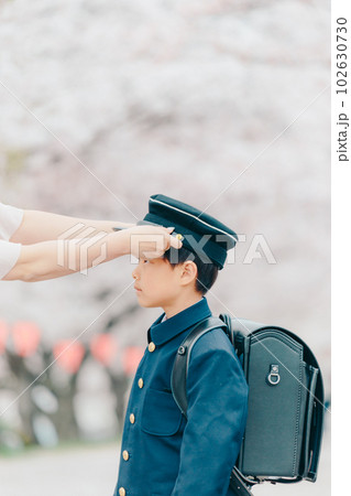 母親に帽子をかけてもらう新一年生 102630730