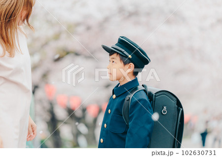 母親に帽子をかけてもらう新一年生 102630731