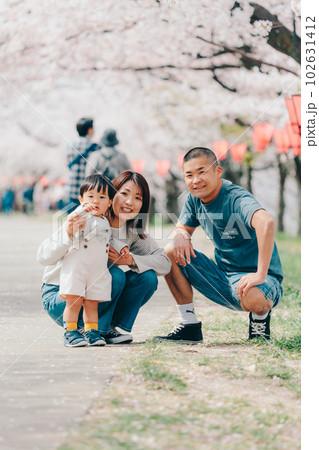 桜の木の下で佇む家族3人の写真 桜の木の下で佇む家族3人の写真 102631412