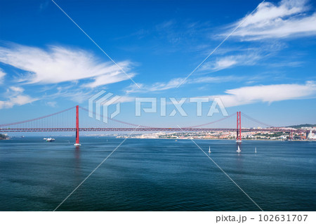 View of 25 de Abril Bridge famous tourist landmark of Lisbon connecting Lisboa to Almada on Setubal Peninsula over Tagus river with boats yachts and vessels. Lisbon, Portugal 102631707
