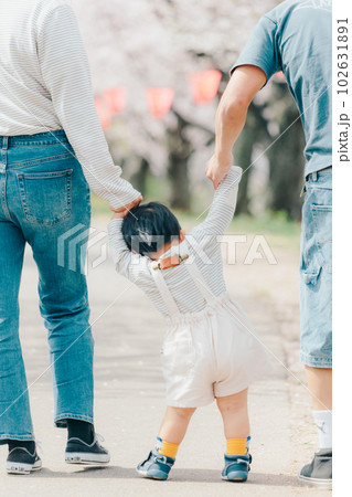 桜の木の下で歩いている家族の写真 102631891