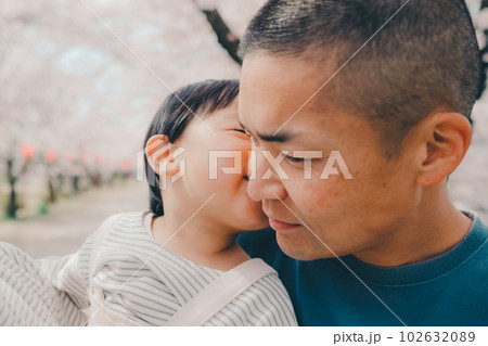 桜バックに子供を抱っこするお父さん 102632089