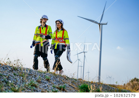 Technicians team with safety uniform working at wind turbine field 102632579