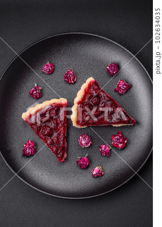 Delicious fragrant sweet pie with cherry berries on a ceramic plate 102634035
