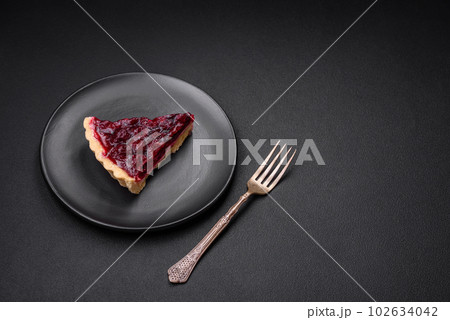 Delicious fragrant sweet pie with cherry berries on a ceramic plate 102634042