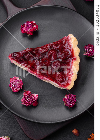 Delicious fragrant sweet pie with cherry berries on a ceramic plate 102634051