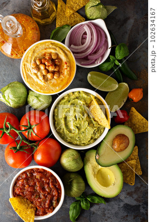 Homemade hummus, salsa and guacamole with corn chips 102634167