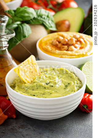 Guacamole and hummus in white bowls Guacamole and hummus in white bowls 102634216
