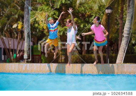 Kids jump into swimming pool. Summer water fun. 102634588