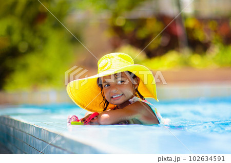 Child in swimming pool on ring toy. Kids swim. 102634591
