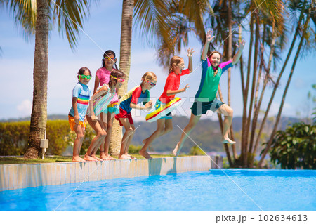 Kids jump into swimming pool. Summer water fun. Kids jump into swimming pool. Summer water fun. 102634613