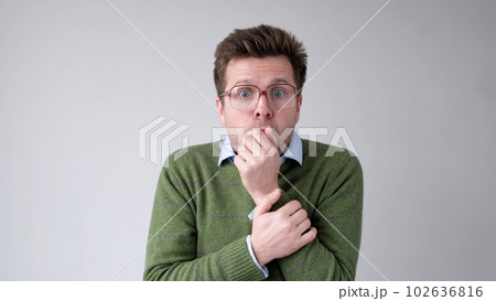 The European young man, in shock, covers his mouth with his hands, thinking, No, this is impossible. The European young man, in shock, covers his mouth with his hands, thinking, No, this is impossible. 102636816