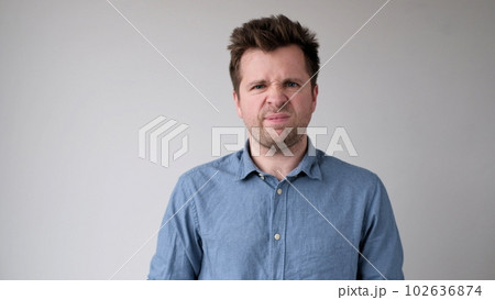 European young man is hesitating and unwilling to make decisions. He is upset about having to do unpleasant work. European young man is hesitating and unwilling to make decisions. He is upset about having to do unpleasant work. 102636874