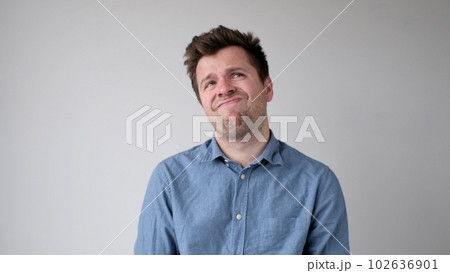 European young man is hesitating and unwilling to make decisions. He is upset about having to do unpleasant work. 102636901