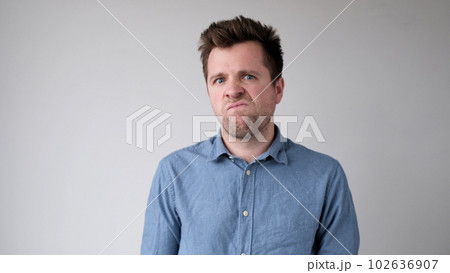 European young man is hesitating and unwilling to make decisions. He is upset about having to do unpleasant work. European young man is hesitating and unwilling to make decisions. He is upset about having to do unpleasant work. 102636907