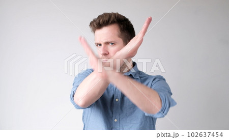 European young man shows a stop sign with his hands European young man shows a stop sign with his hands 102637454