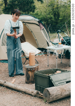 女性ソロキャンプで薪割りをする 102638500