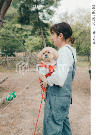 女性ソロキャンプで愛犬と戯れる 102639063
