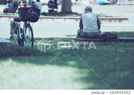 公園で座り込む男性の後ろ姿 公園で座り込む男性の後ろ姿 102644382