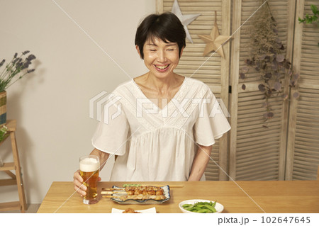 自宅で一人で晩酌をする中年女性 102647645