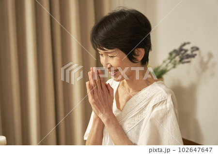 自宅で手を合わせていただきますをする中年女性 102647647