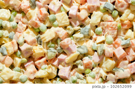 Olivier salad close-up, above view. Mayonnaise salad full frame background Olivier salad close-up, above view. Mayonnaise salad full frame background 102652099