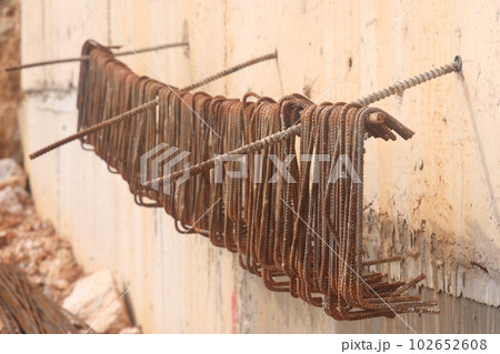Rusty steel wire on the wall of the building construction site. Blanks for bent reinforcement. 102652608