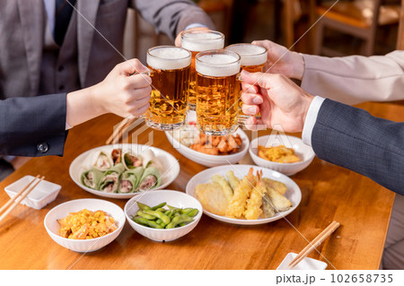 居酒屋でビールジョッキを持って乾杯・忘年会・新年会・飲み会・宴会をする仕事仲間・同僚・上司部下の男女 居酒屋でビールジョッキを持って乾杯・忘年会・新年会・飲み会・宴会をする仕事仲間・同僚・上司部下の男女 102658735