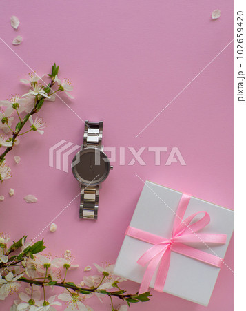 Womens wristwatch on pink background with cherry flowers and copy space Womens wristwatch on pink background with cherry flowers and copy space 102659420
