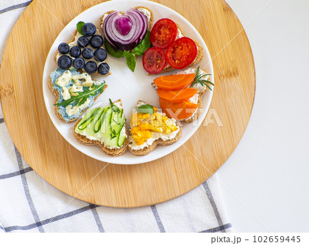 Rainbow sandwiches heart shape on white table 102659445