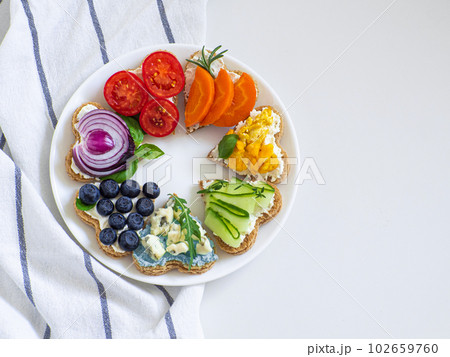 Rainbow sandwiches heart shape on white table 102659760