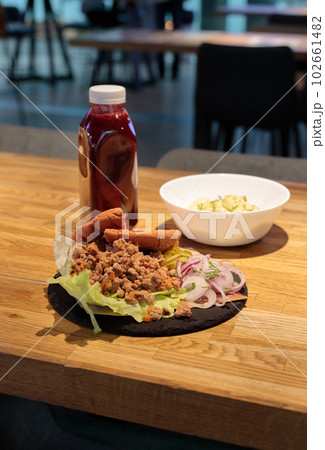 Lunch at the food court counter. A drink in a bottle and a tortilla on a plate. 102661482
