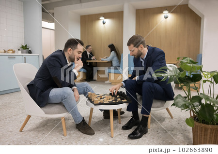 Two business professional men playing chess in office cafe Two business professional men playing chess in office cafe 102663890