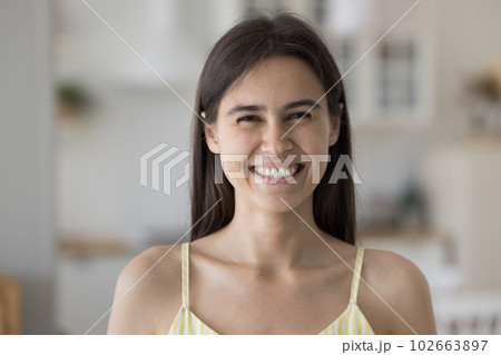 Cheerful beautiful Hispanic girl wearing sleeveless top, posing indoors 102663897