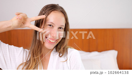 Portrait of young gorgeous smiling woman in white bathrobe looking at camera Portrait of young gorgeous smiling woman in white bathrobe looking at camera 102664138