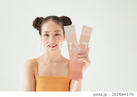 Asian beauty woman hold color scale with sun protection uv or sunscreen on the white background 102664170