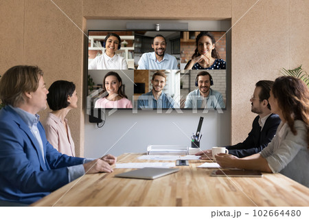 Multiethnic applicants on TV screen during group job interview event Multiethnic applicants on TV screen during group job interview event 102664480