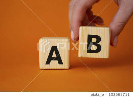 Plan A and Plan B. Businessman hand is making a choice between Plan A and Plan B symbol. Beautiful orange background. Business concept. Copy space. 102665711