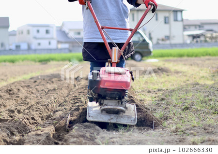 家庭菜園で野菜作りをする女性　農業女子　耕運機で畑を耕す女性 102666330