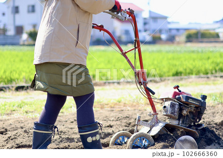 家庭菜園で野菜作りをする女性　農業女子　耕運機で畑を耕す女性 102666360