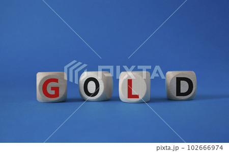 Gold symbol. Concept word Gold on wooden cubes. Beautiful blue background. Business and Gold concept. Copy space. 102666974