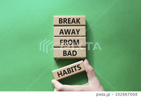 Break away from bad habits symbol. Wooden blocks with words Break away from bad habits. Beautiful green background. Businessman hand. Business and Break away from bad habits concept. Copy space. 102667008