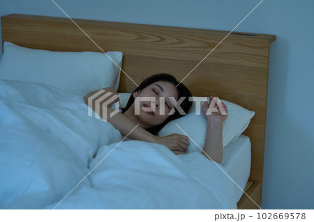 ベッドで眠る若い女性 102669578