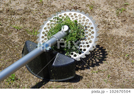 草刈機の刃の中心部分に草が巻き付いた状態 草刈機の刃の中心部分に草が巻き付いた状態 102670504